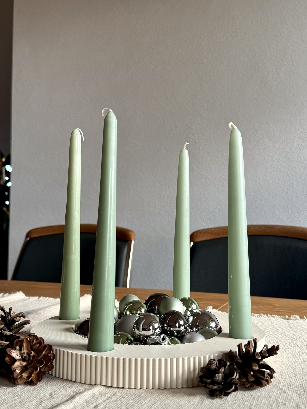 hellgrüne Kerzen und wenig Tannenzapfen 