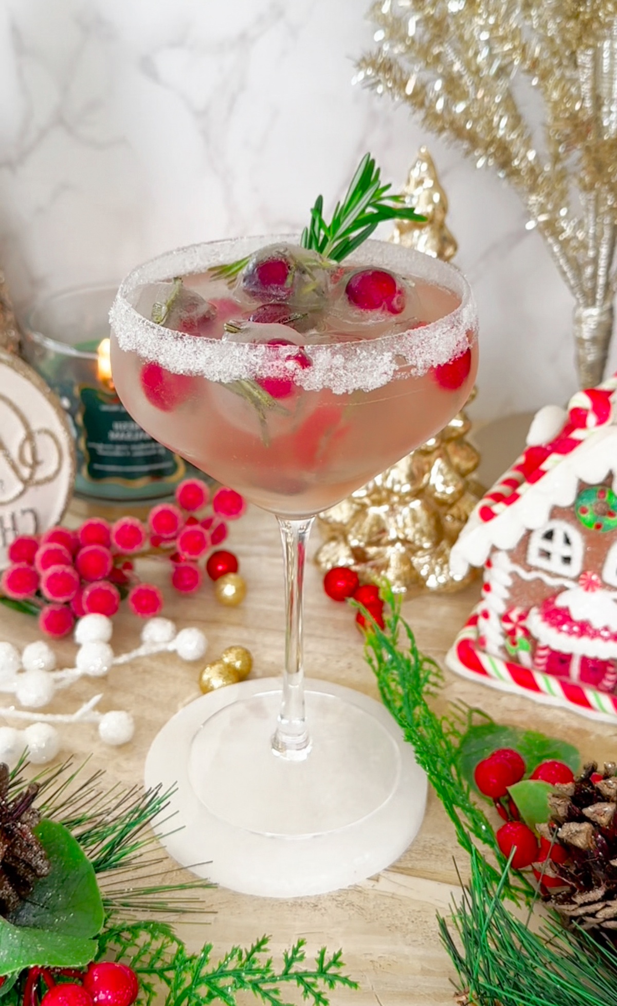 Ein Cocktail mit Cranberrys und Rosmarin dekoriert