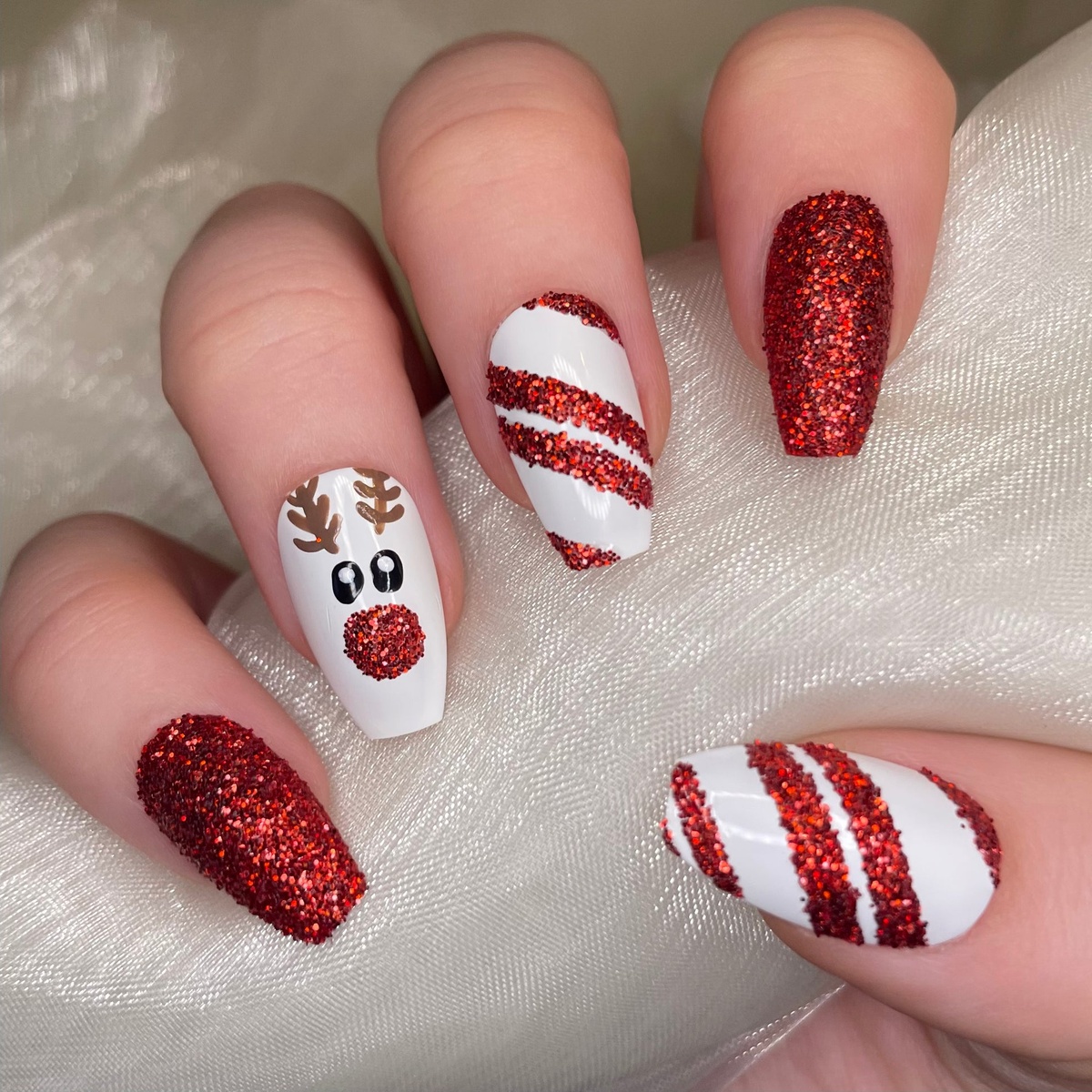 Wei´und glitzerndes Rot aus Christmas Nails mit einem Rentier Motiv