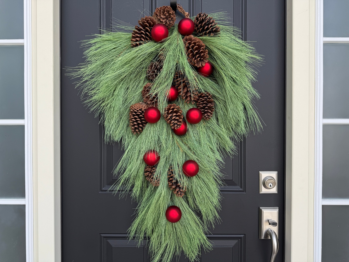 Türkranz aus grünen Kieferzweigen, Zapfen und roten Kugeln 