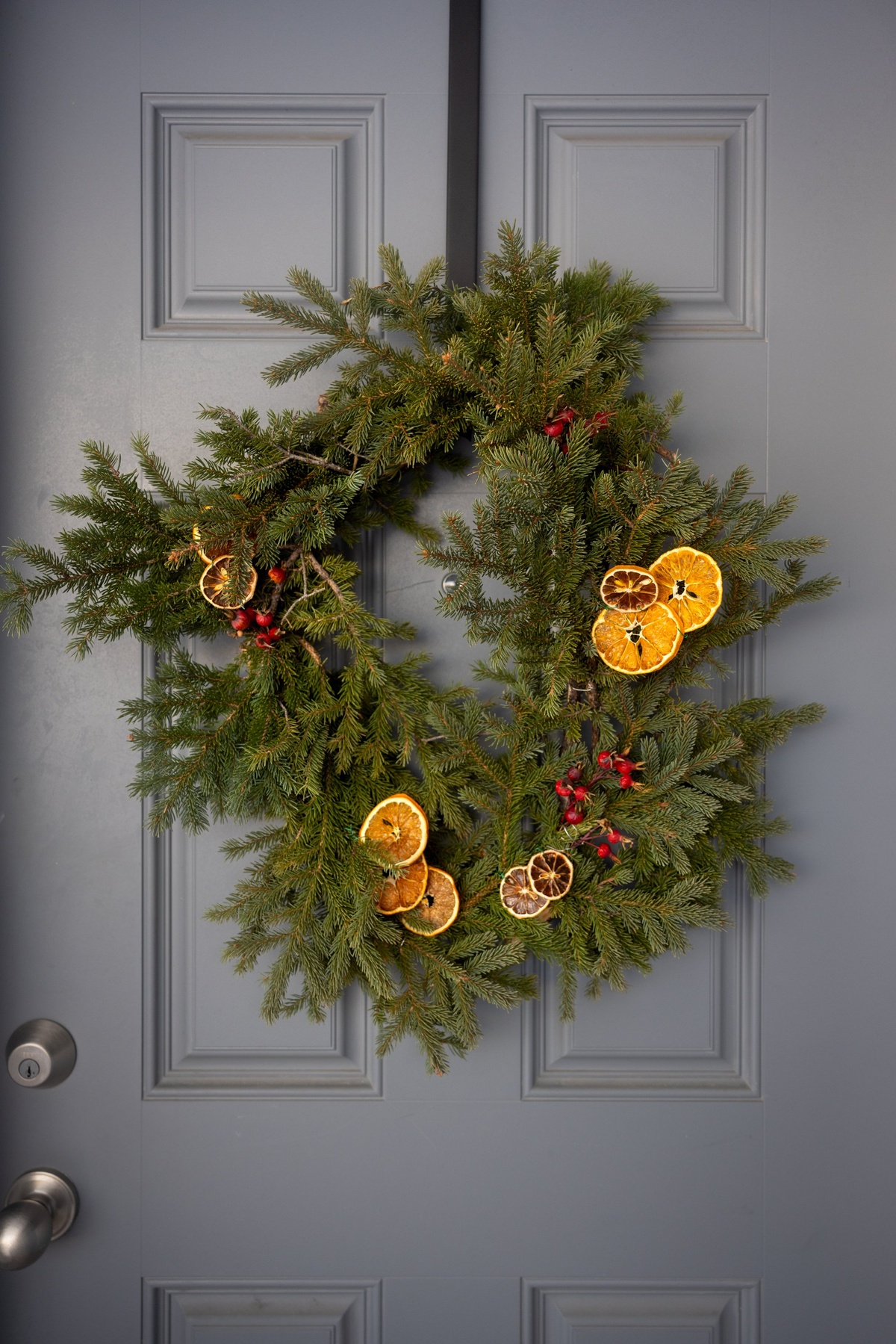 getrocknete Orangenscheiben mit roten Stechpalmenbeeren als Deko