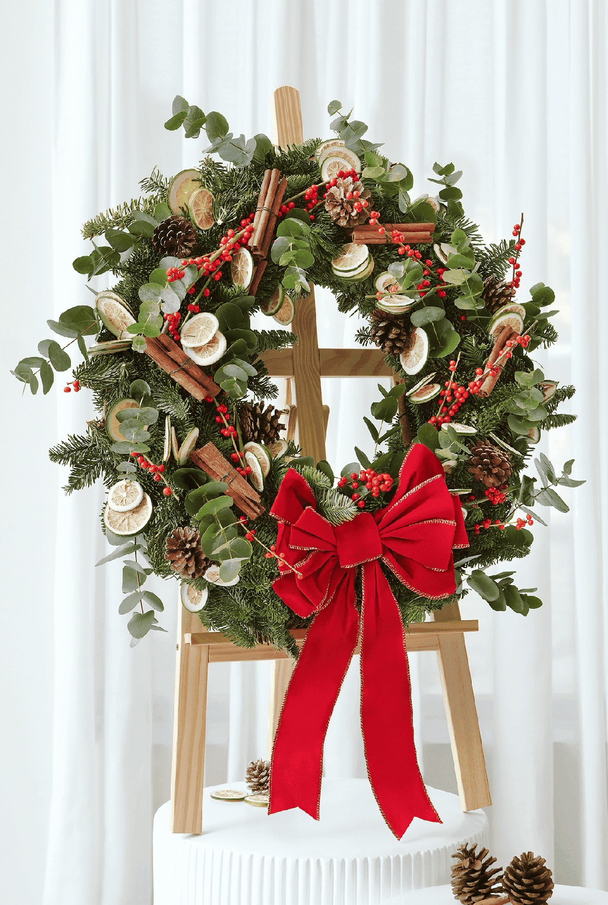 ein prächtig dekorierter weihnachtlicher Kranz auf Holzständer