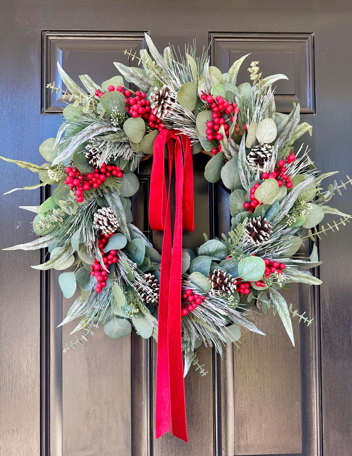Eukalyptus Zweite, Zapfen,rote Stechpalmenbeeren und rote Schleife als Deko 