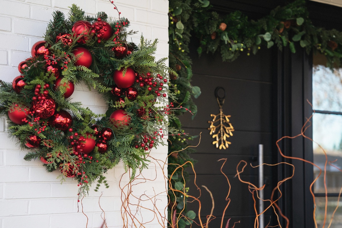 schön dekorierter Türkranz zu Weihnachten mit roten Kugeln 