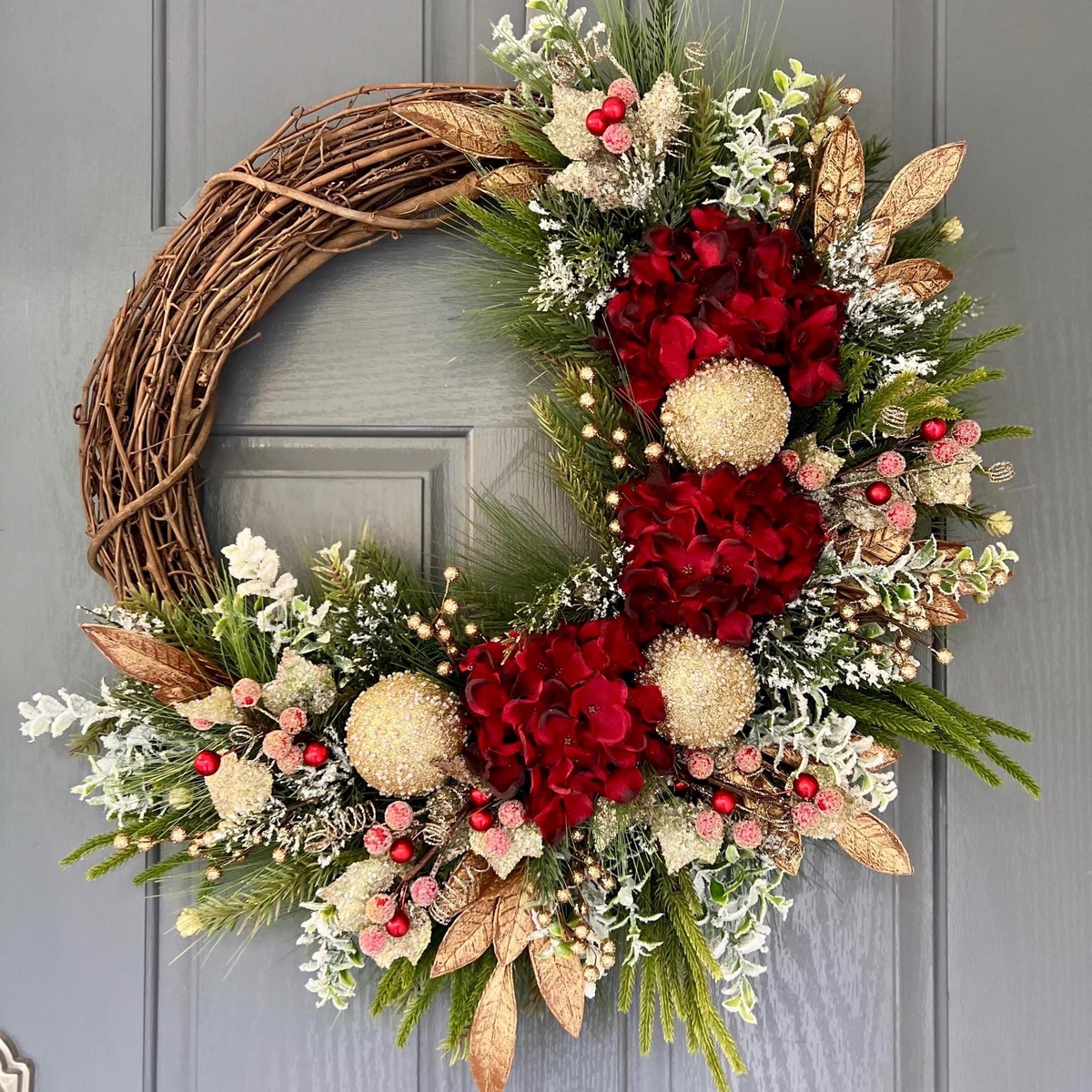 ein schöner Türkranz mit trockenen Gräsern, Blüten und grünen Zweigspitzen