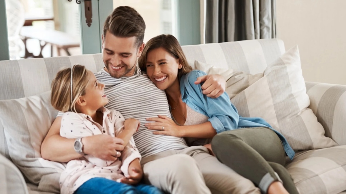 junge Familie mit einer kleinen Tochter auf der Couch zu hause