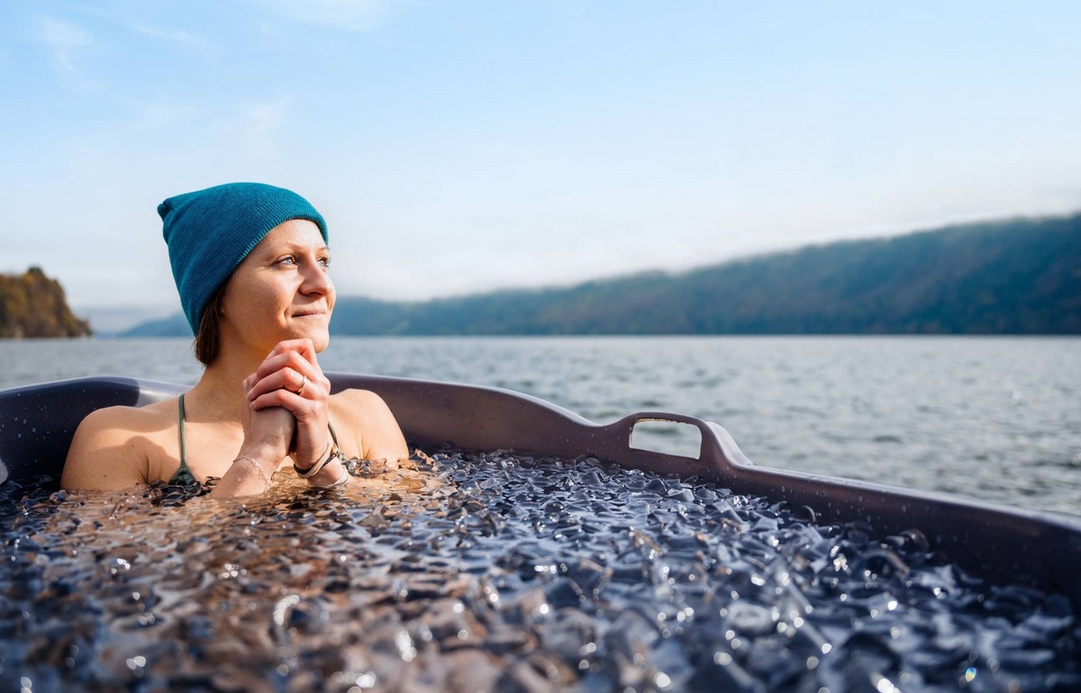 eine Frau mit Mütze badet in ice tube