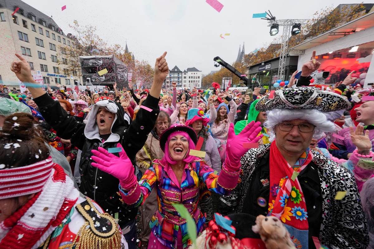bunt gekleidete Menschen feiert Fasching auf der Straße