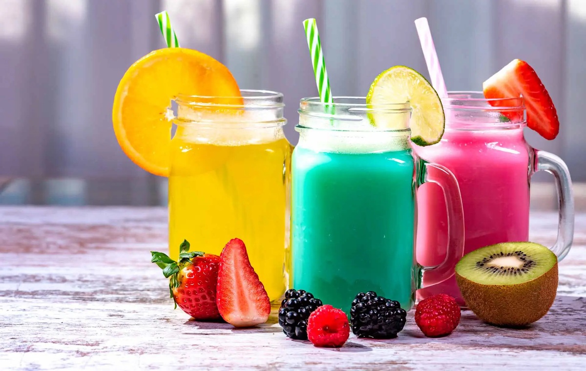 drei Gläser verschiedene Säfte mit KIwi und Beeren