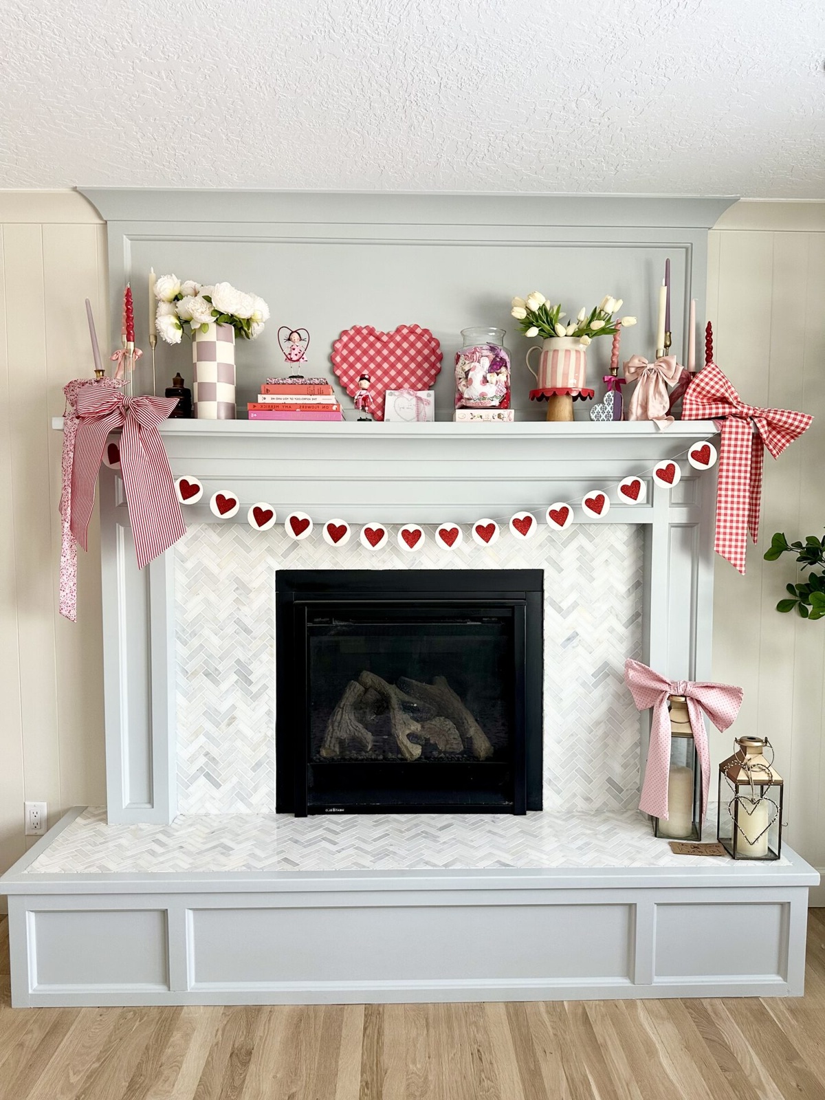 den Kaminsims zum Valentinstag dekorieren mit Girlande, Blumen und Herzen 