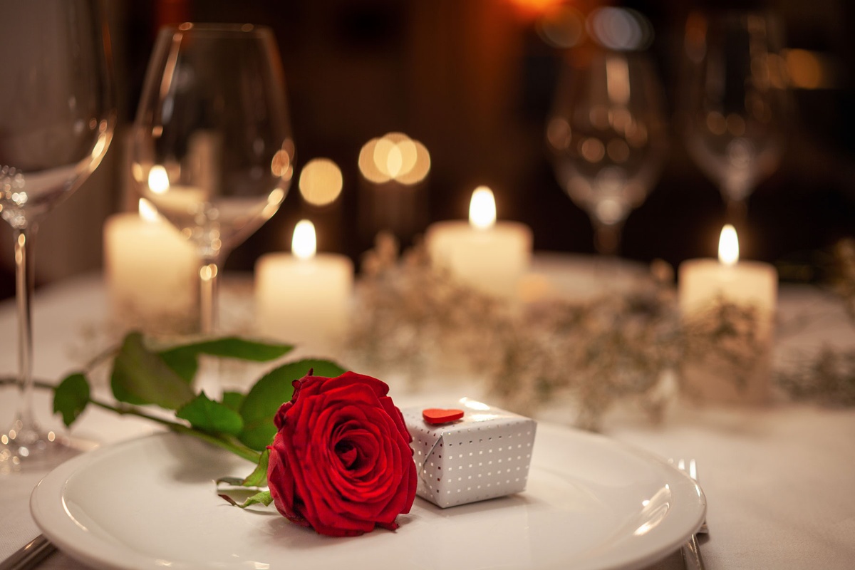 rote Rose, kerzenlicht und nettes Geschenk am Valentinstag 