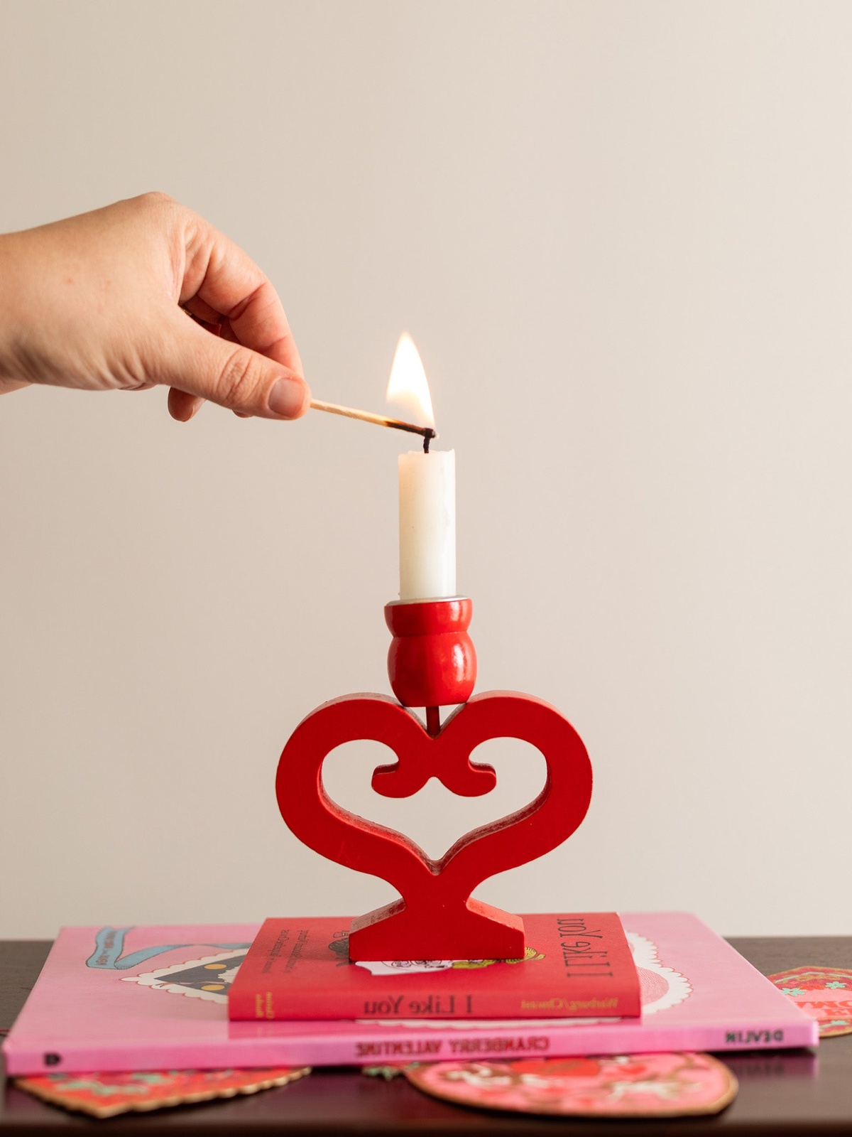 Valentinstag Deko - weoße Kerze anzünden am roten Kerzenständer in Herzform 