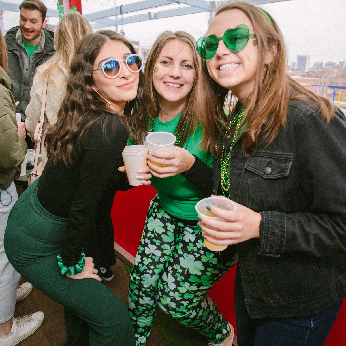 Mädchen feiern den St. Patricks Day und trinken Bier