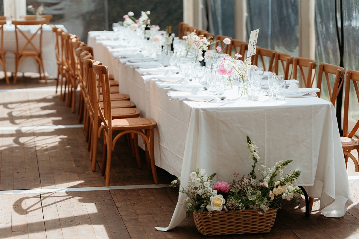 langer Esstisch festlich gedeckt und mit Blumen dekoriert