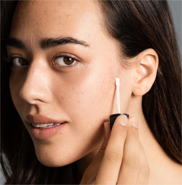 Junge Frau verwendet Retinol Serum