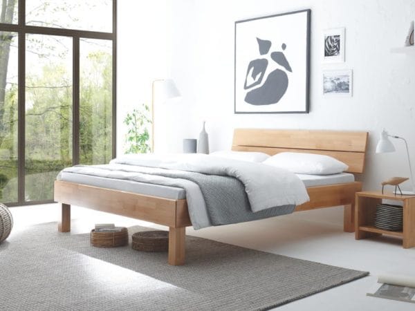 ein modernes Holzbett steht im hellen Schlafzimmer