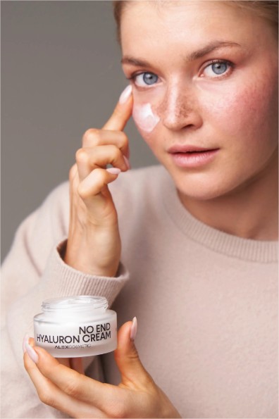 junge Frau trägt Retinol Creme mit Hyaluronsäure aufs Gesicht auf