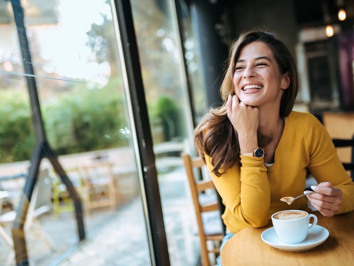 junge Frau trinkt Kaffee und fühlt sich gut gelaunt